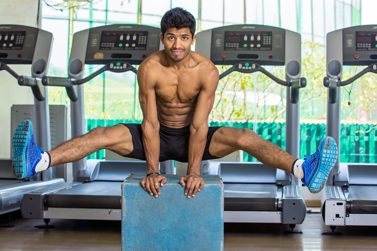 hero-img-02 Shirtless muscular man performing calisthenics in an indoor gym in Chandigarh, India.
